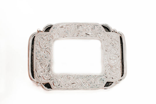 Silver rectangular windowed belt buckle with intricate engravings on a white background