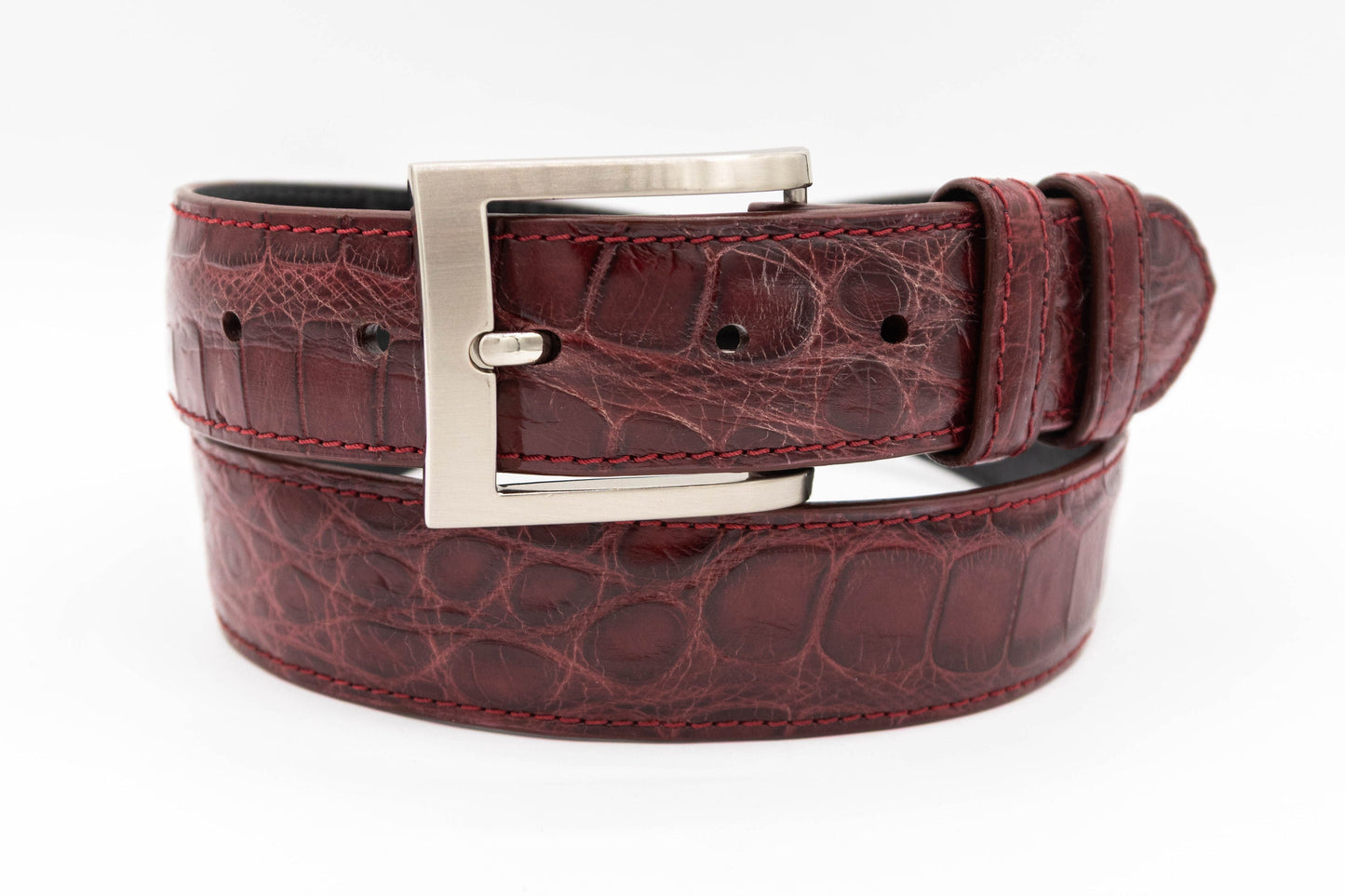 Burgundy Alligator leather belt with a silver buckle on a white background