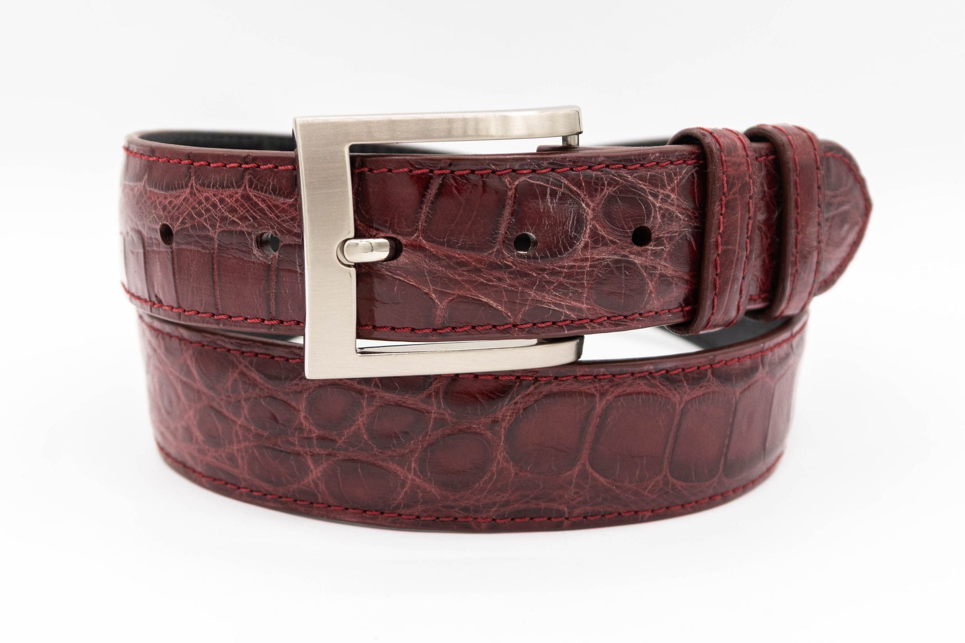 Burgundy Alligator leather belt with a silver buckle on a white background
