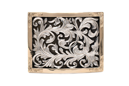 Decorative belt buckle with intricate silver design, 14kt gold bezel on a black background